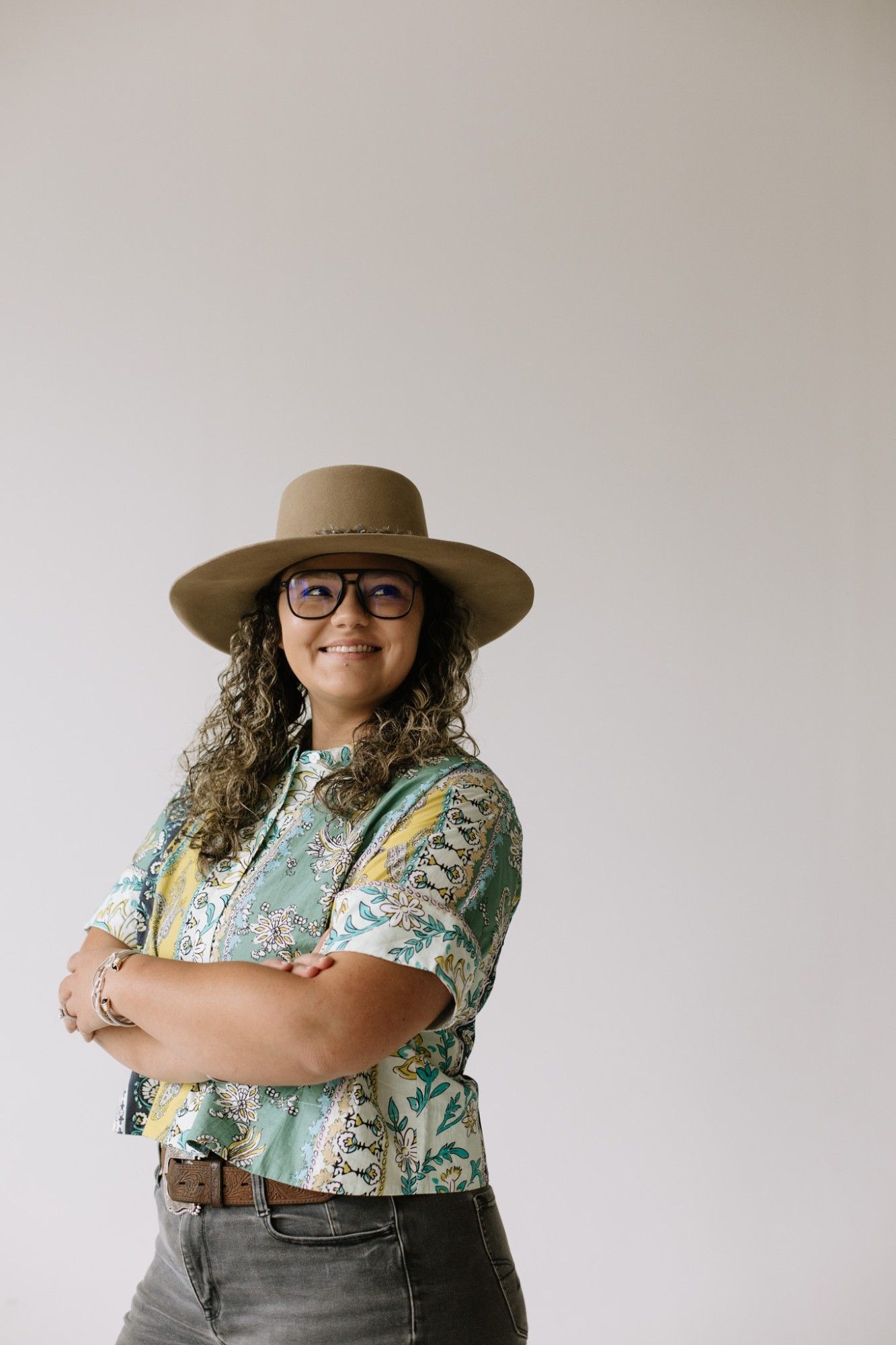 Olivia Gentry Williams, REALTOR® with Southern Real Estate Properties, smiling with arms crossed in a tan wide-brim hat